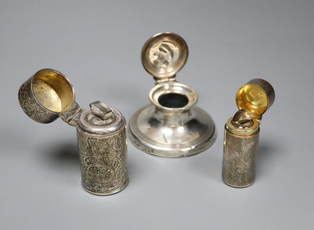 A silver capstan inkwell and two silver-cased cylindrical scent bottles